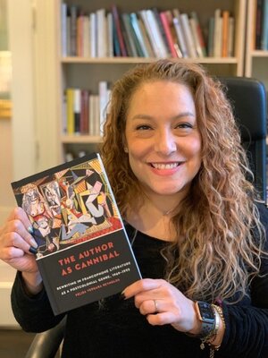 Professor Reynolds holding a published copy of her book