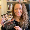 Professor Reynolds holding a published copy of her book